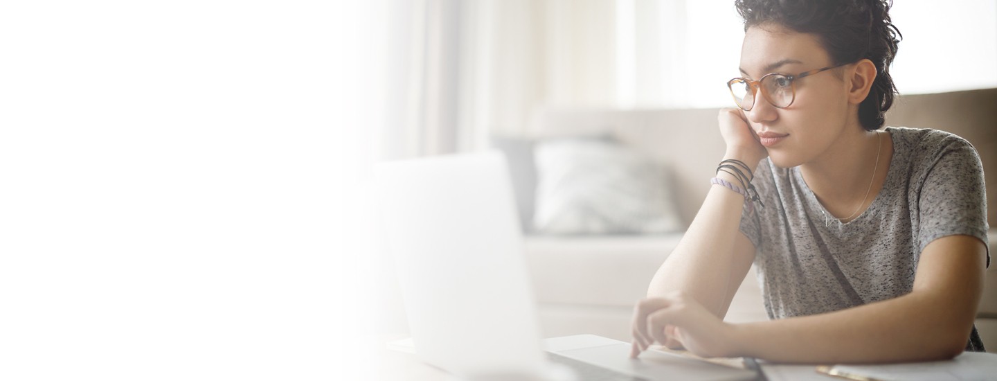 Left white gradient cropped 2880x110 of young woman working on laptop at home