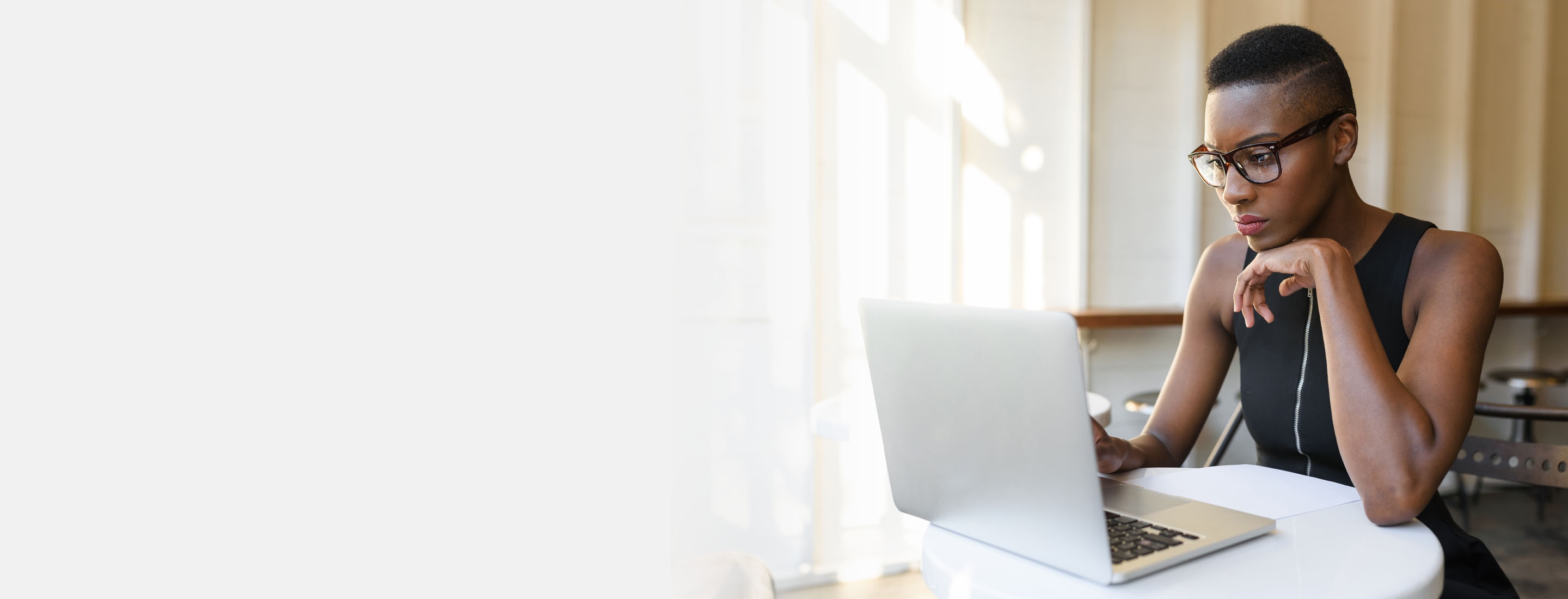 2880x1100 left gray gradient of an African business woman working hard at the cafe on the laptop