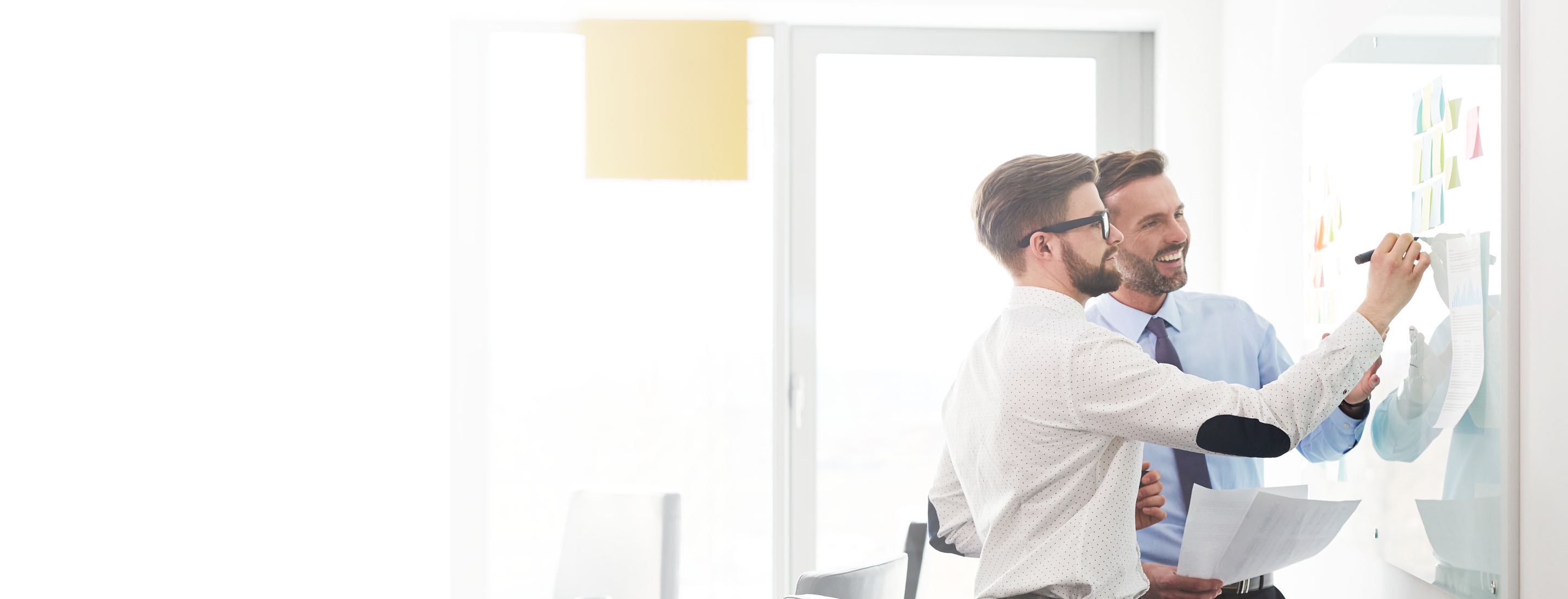 2880x1100 left white gradient of two businessmen working at office planning new strategy on whiteboard