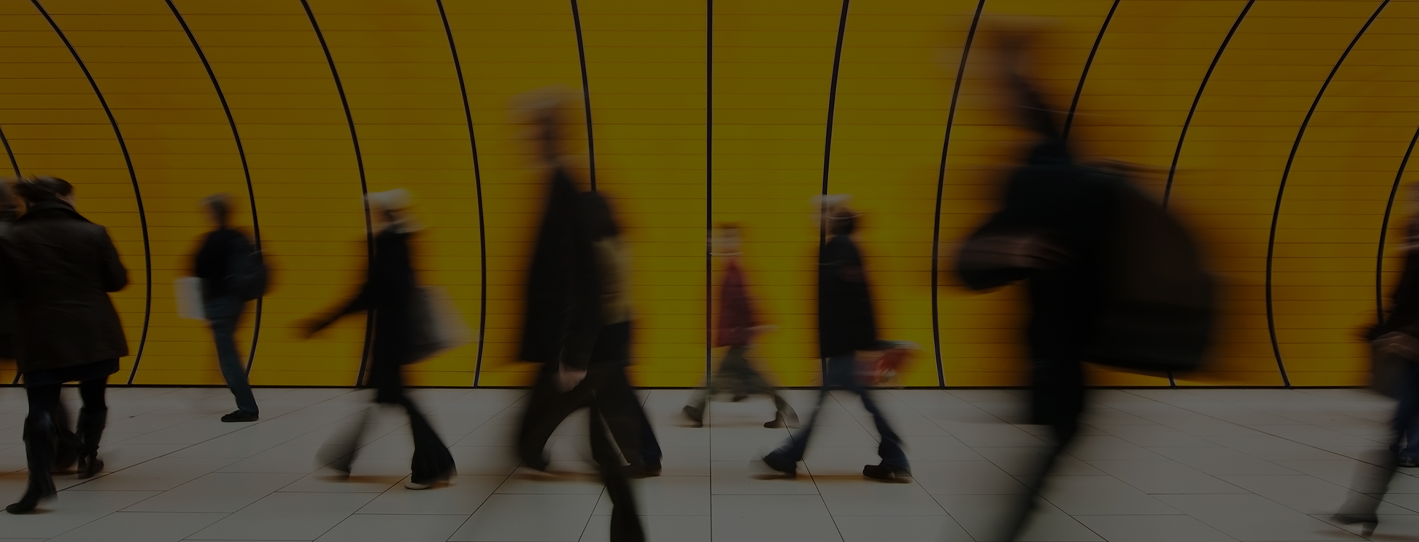 blurred and defocused people walking in orange subway