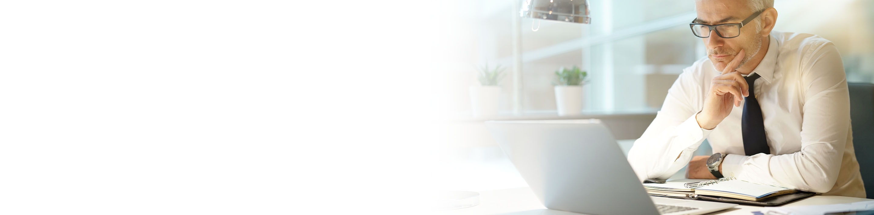 2880x710 left white gradient of a businessman working on laptop in office, being concerned