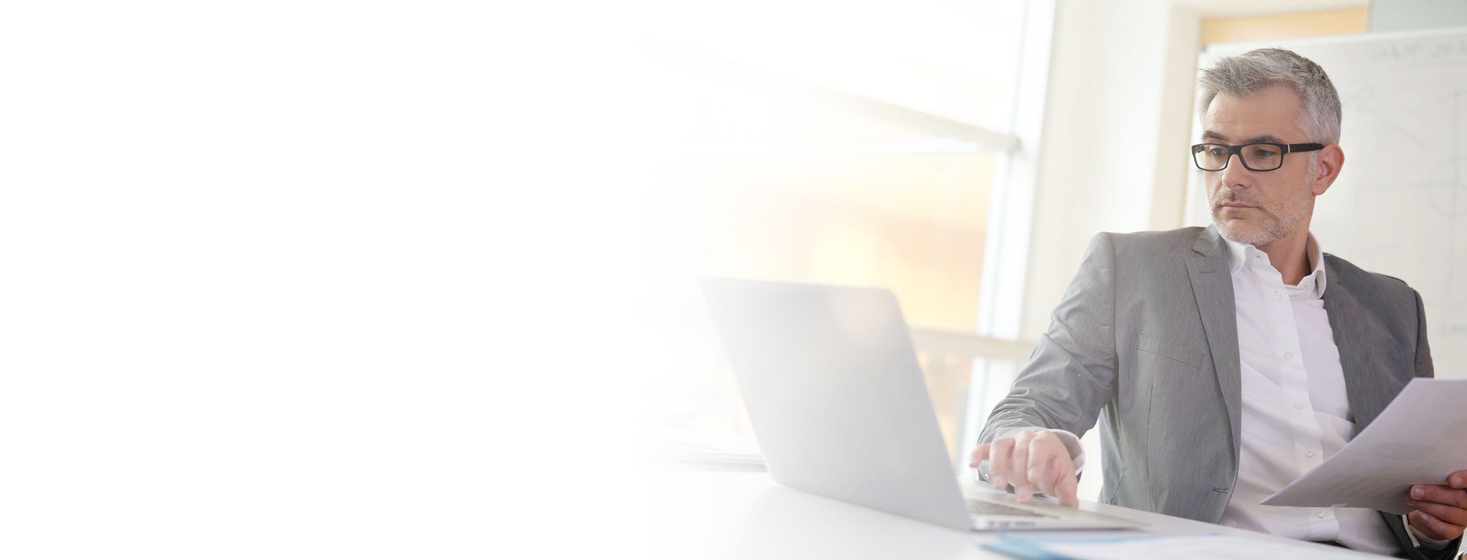 2880x1100 flipped horizontal left white gradient of a businessman in office working on laptop