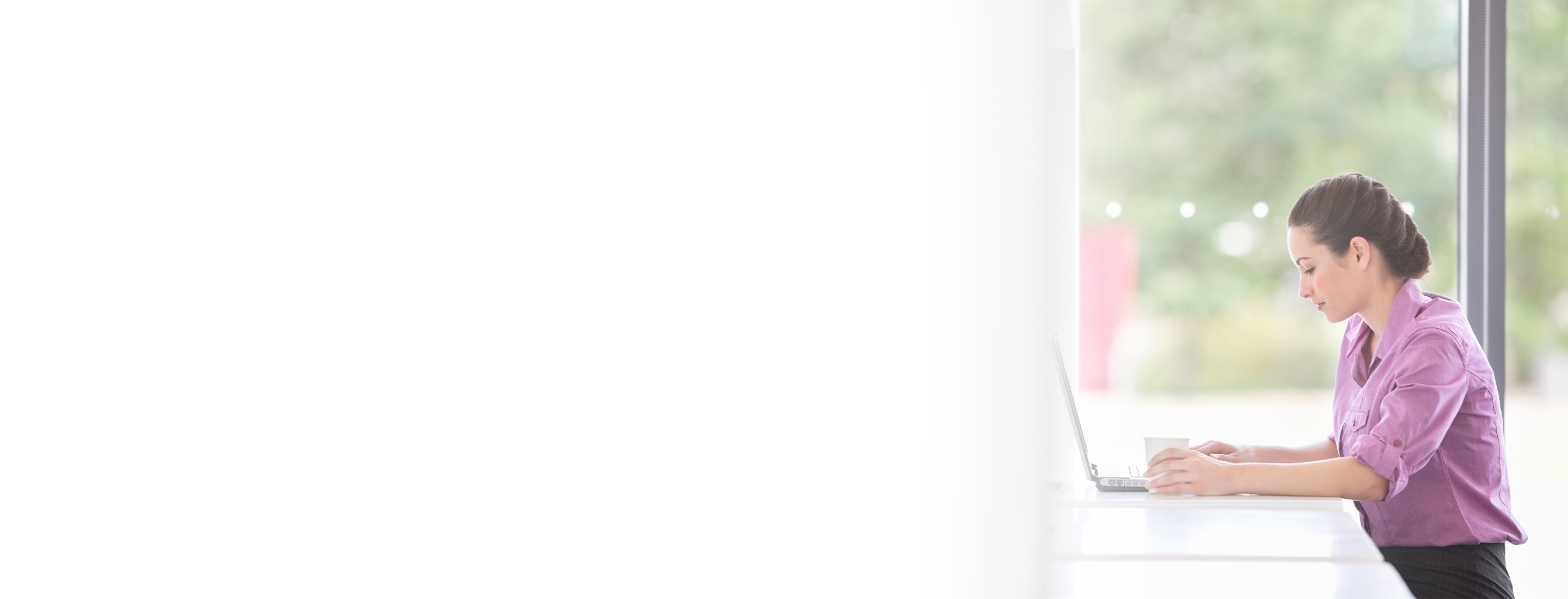 Cropped 2880x1100 left white gradient of  a businesswoman executive working on laptop at office cafeteria