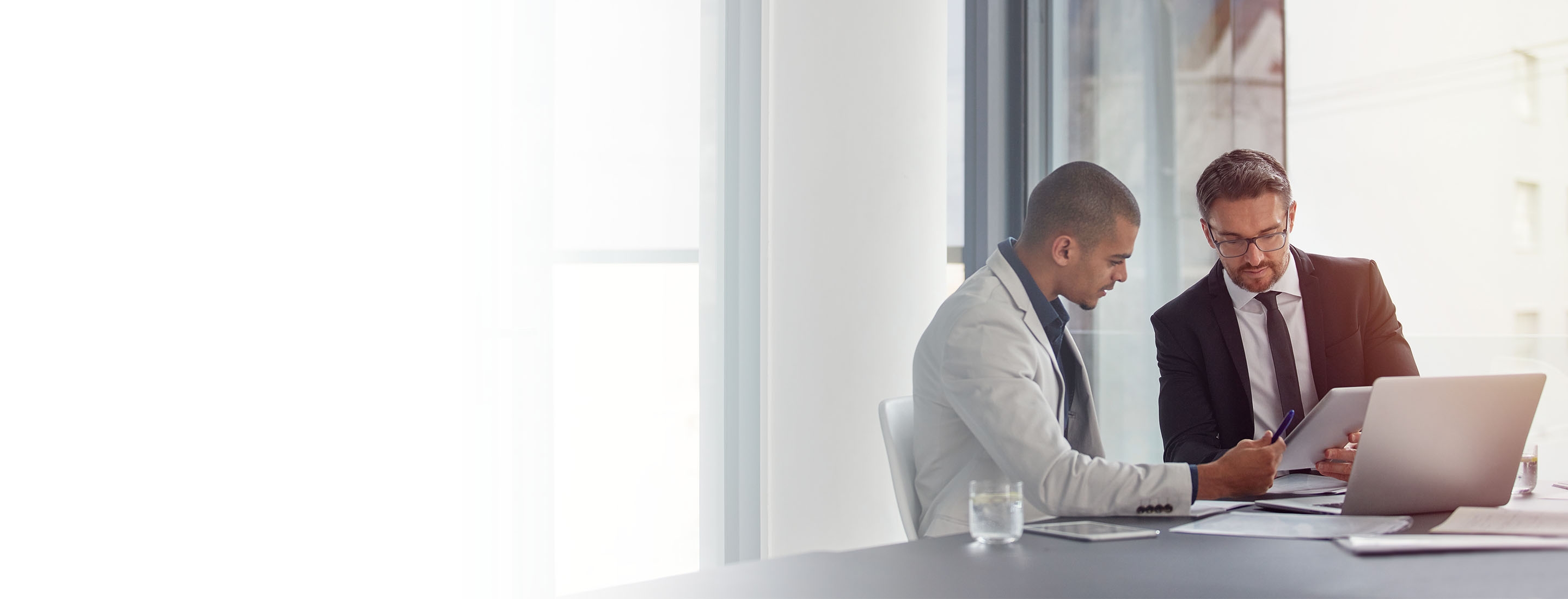 2880x1100 left white gradient of two businessmen having an office meeting