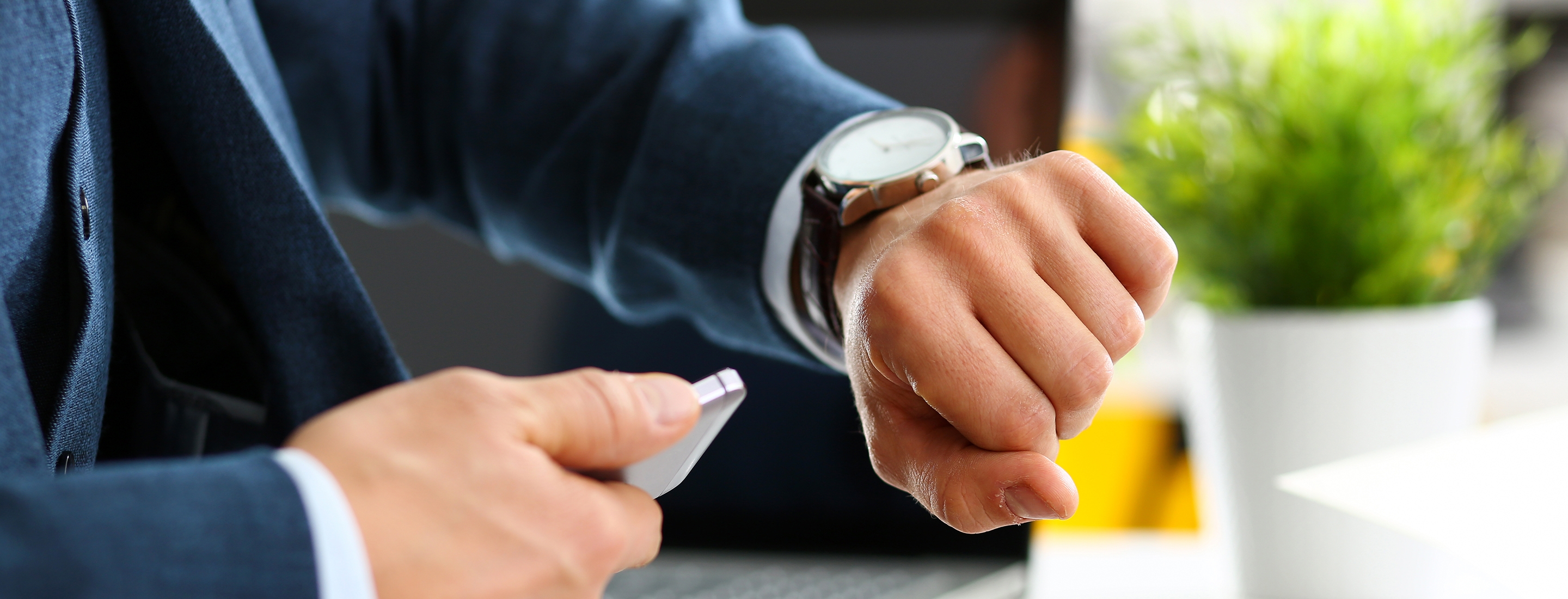 man in suit and tie check out time at silver wristwatch closeup