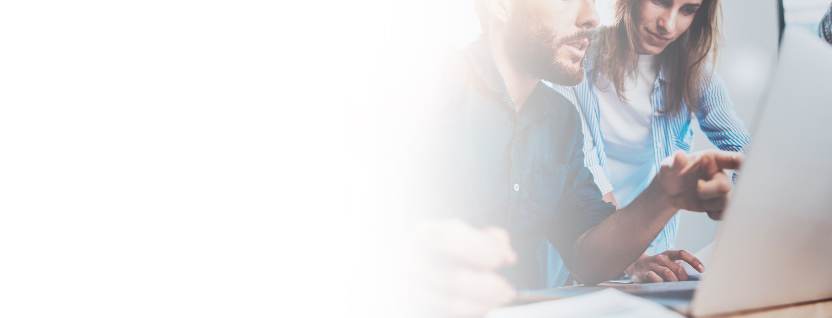 Cropped 2880x1100 left white gradient of group of coworkers sitting at the wooden table and working together on new startup project in modern loft office