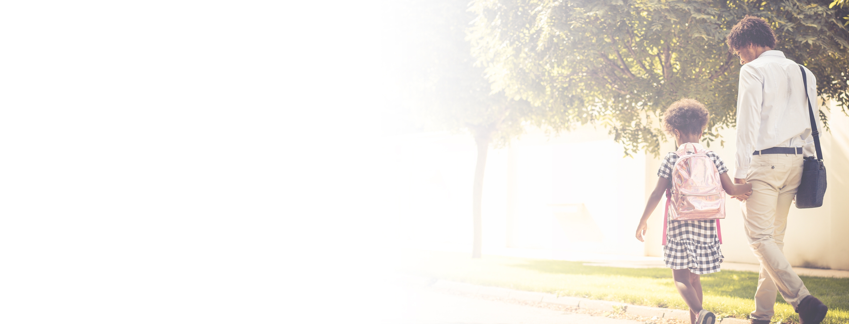 Cropped 2880x1100 flipped horizontal left white gradient of African American father and his daughter walking trough park. From back.