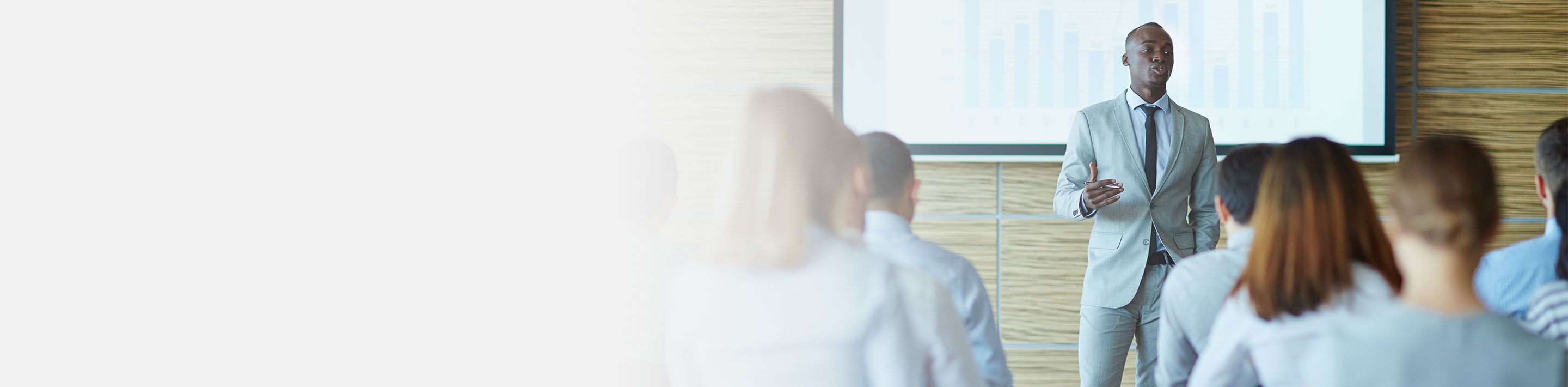 2880x1100 left gray gradient of a young teacher presenting new project to managers