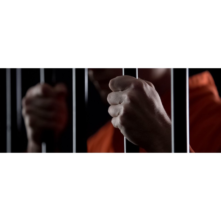 2880x1100 of a desperate criminal holding jail bars feeling regret for committing crime closeup