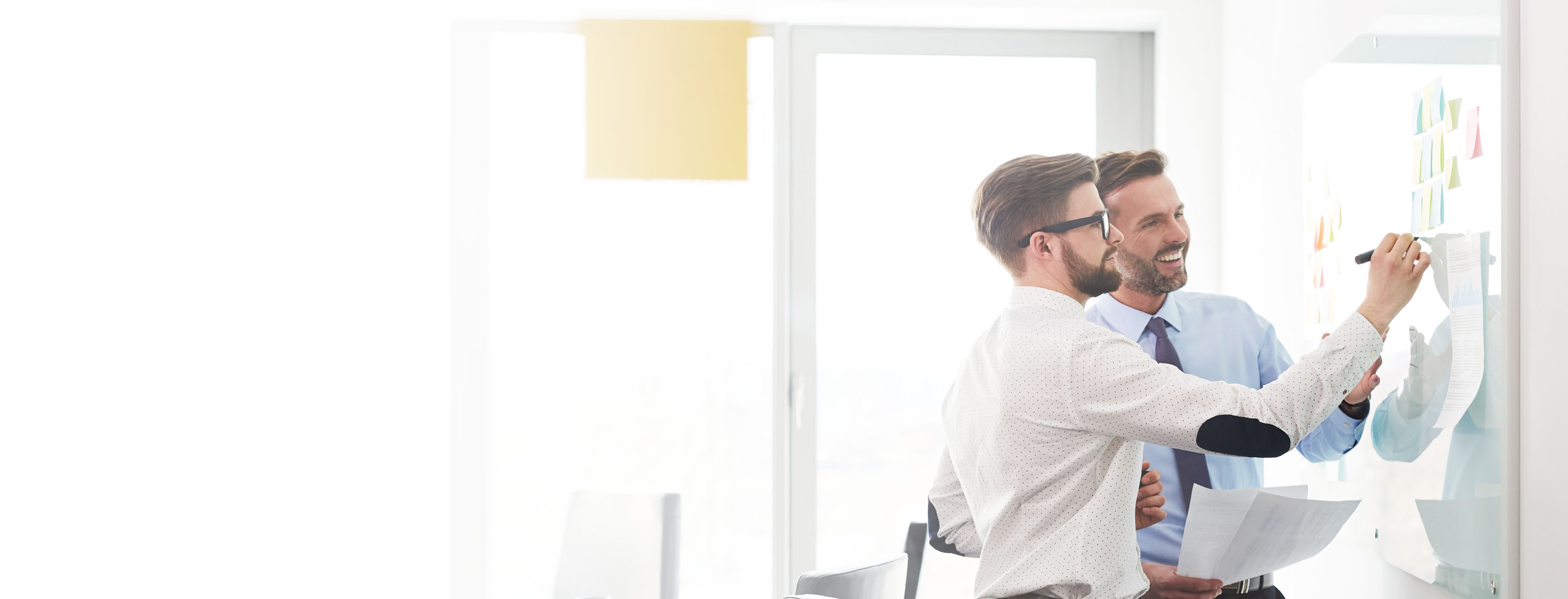 2880x1100 left white gradient of two businessmen working at office planning new strategy on whiteboard
