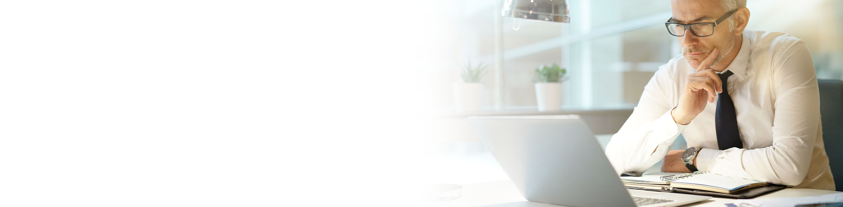 2880x710 left white gradient of a businessman working on laptop in office, being concerned