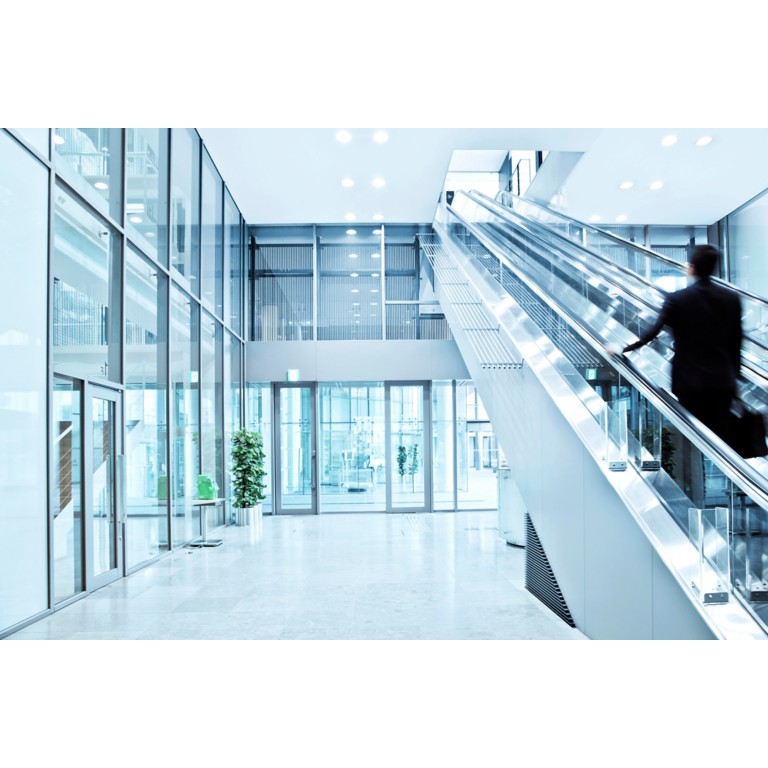 Business man walking up a escalator, Blurred Motion