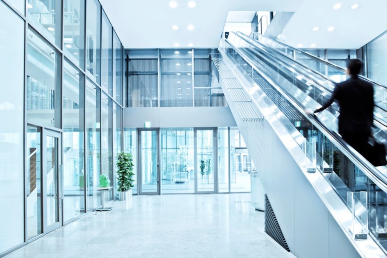 Business man walking up a escalator, Blurred Motion
