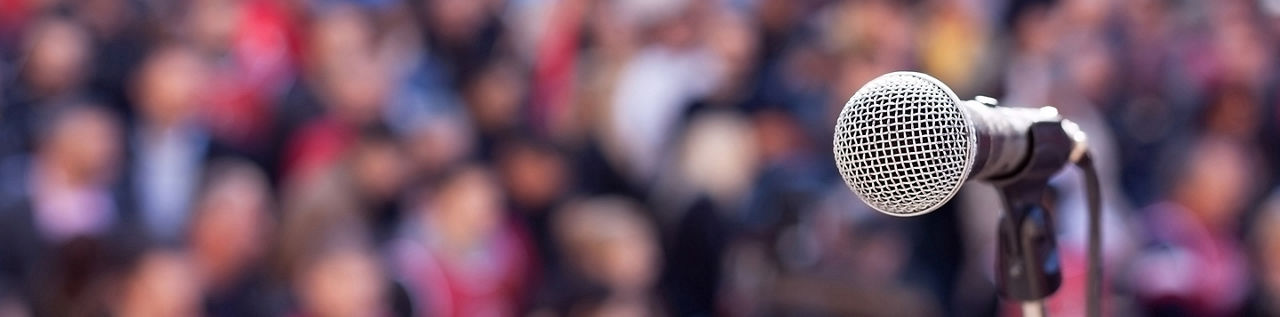 Microphone in focus against unrecognizable crowd 