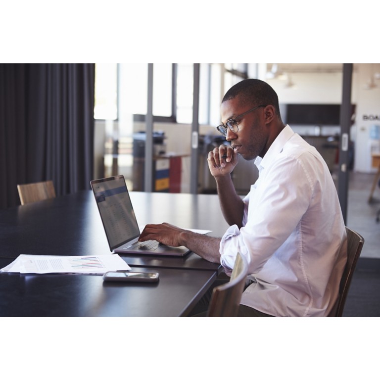 man-wearing-glasses-using-laptop-office