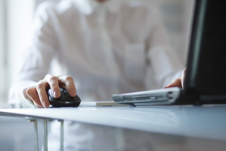 womans-hand-using-cordless-mouse-glass-table
