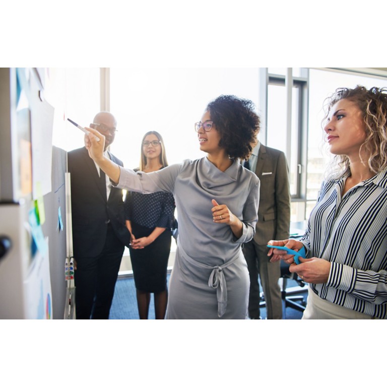 diverse-group-focused-businesspeople-brainstorming-whiteboard