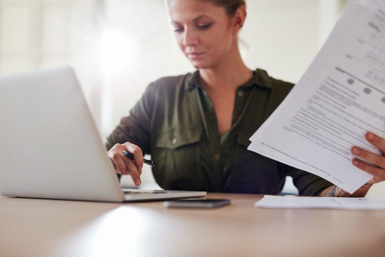 woman-table-documents-working-laptop