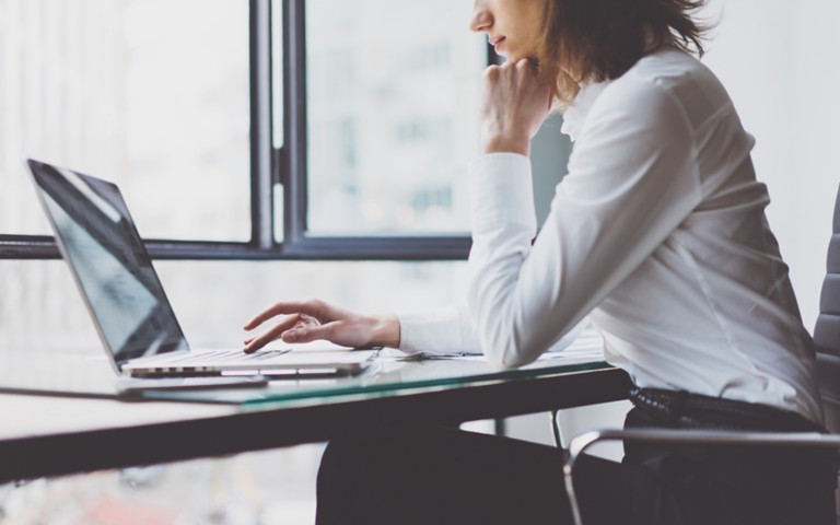 modern-office-woman-wood table-typing-keyboard-laptop