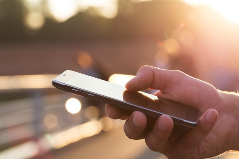 man-using-mobile-phone-outdoor-closeup