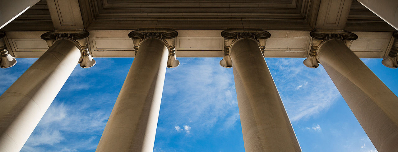 Cropped 2880x1100 of building column on a government building with a beautiful blue sky.