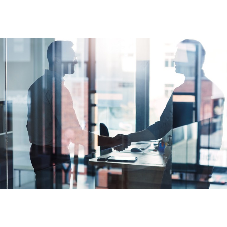 Shot of two businessmen shaking hands in an office