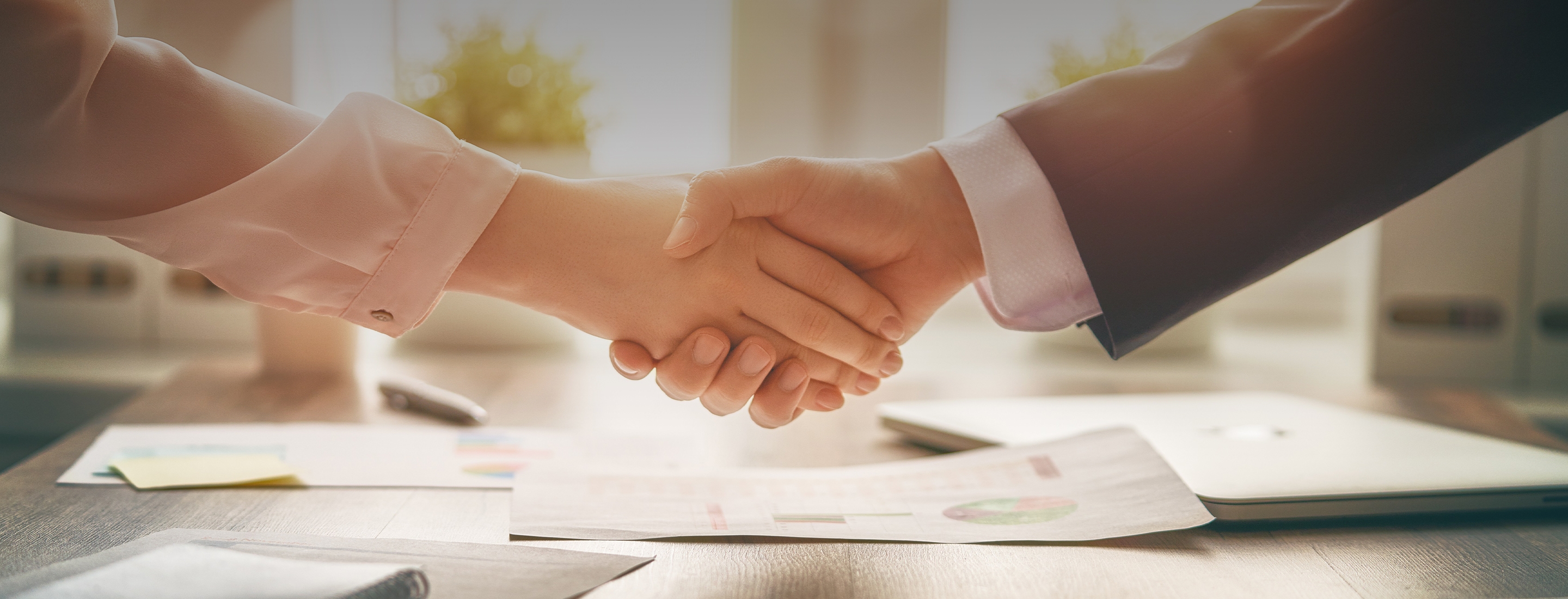 2880x1100 top black gradient of man and woman are shaking hands in office. Collaborative teamwork.