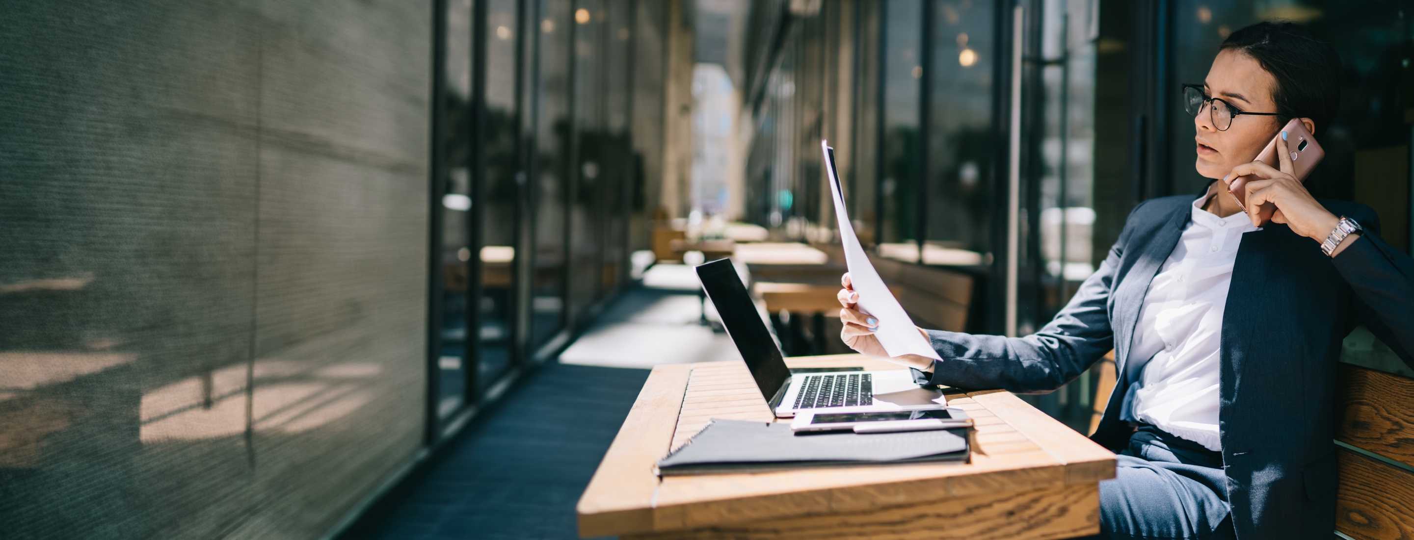 mulher sentada falando ao telefone enquanto olha o computador