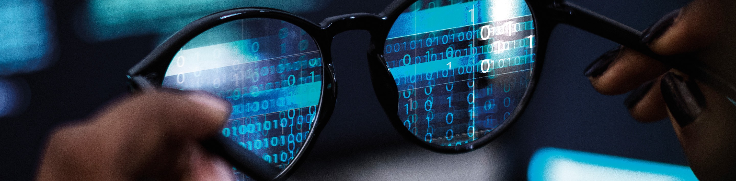 Abstract image of computery binary code shown through eyewear lenses.
